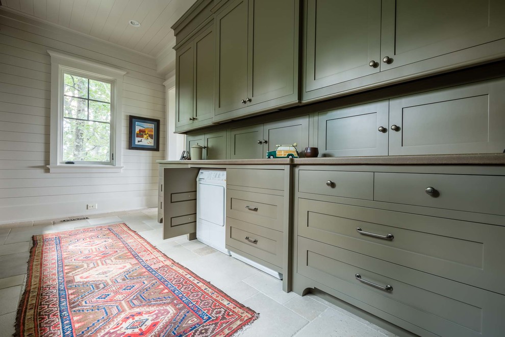 Inspiration for a large country laundry room in Nashville with a farmhouse sink, recessed-panel cabinets, green cabinets, wood benchtops, beige floor and slate floors.