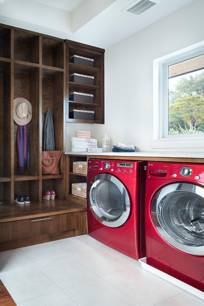 Design ideas for a mid-sized transitional l-shaped utility room in Austin with flat-panel cabinets, dark wood cabinets, white walls and a side-by-side washer and dryer.