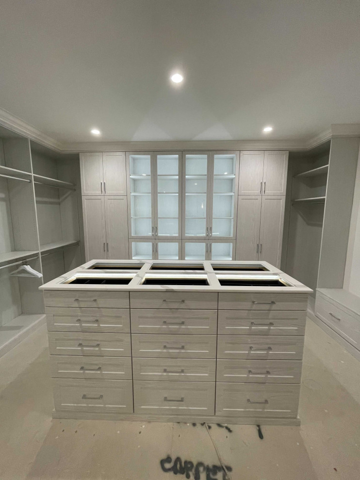 Photo of a large gender-neutral walk-in wardrobe in Los Angeles with shaker cabinets, grey cabinets and laminate floors.