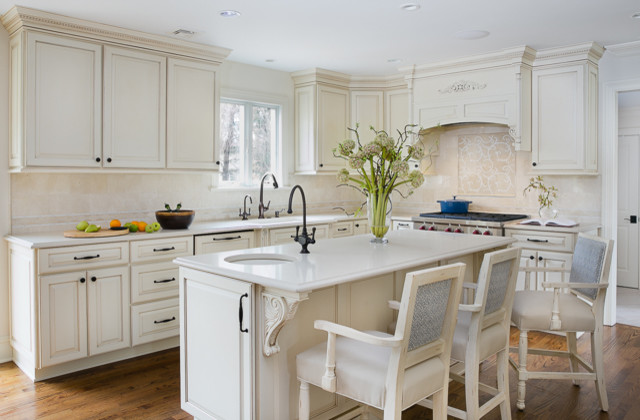 Example of a large transitional light wood floor eat-in kitchen design in Newark with an undermount sink, raised-panel cabinets, paneled appliances, an island, white cabinets, quartzite countertops, beige backsplash and stone tile backsplash