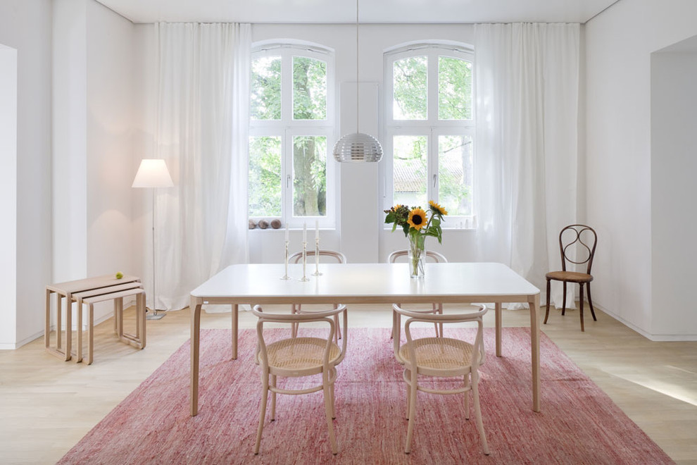 This is an example of a mid-sized scandinavian open plan dining in Other with white walls and light hardwood floors.
