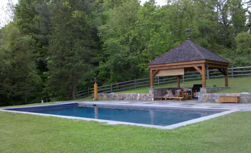 Photo of a mid-sized arts and crafts backyard rectangular lap pool in New York with concrete pavers.
