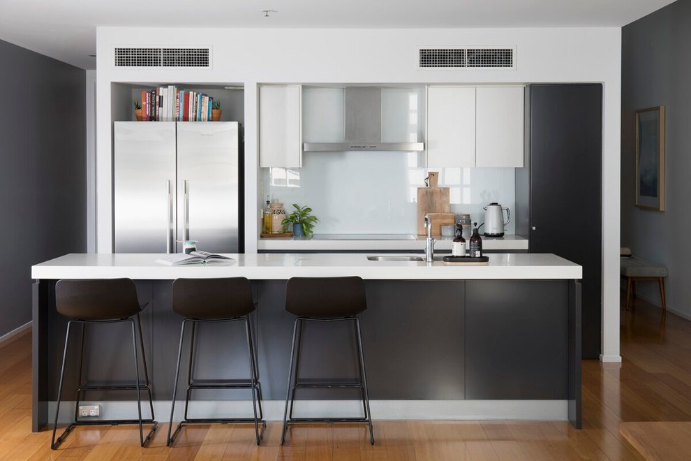 This is an example of a mid-sized midcentury galley eat-in kitchen in Brisbane with black cabinets, quartzite benchtops and with island.