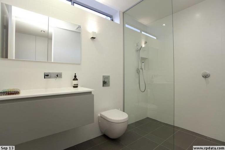 Small contemporary master bathroom in Brisbane with raised-panel cabinets, an open shower, a wall-mount toilet, white tile, ceramic tile, white walls, porcelain floors, an integrated sink and engineered quartz benchtops.