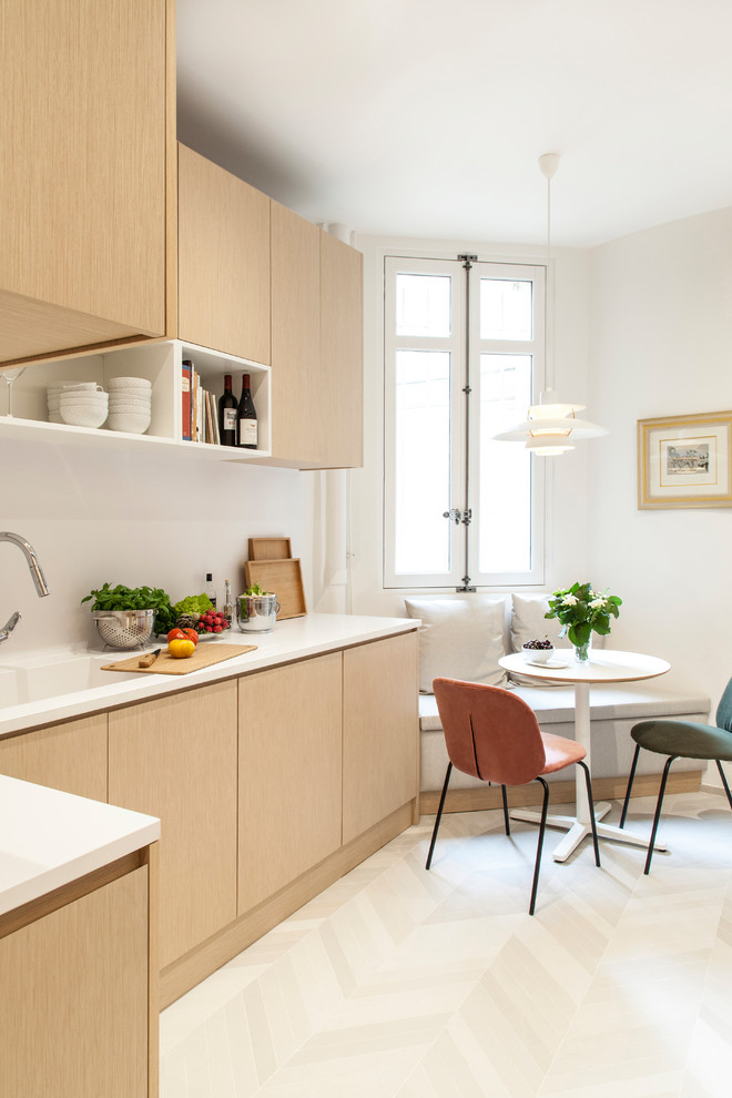 Photo of a mid-sized contemporary l-shaped eat-in kitchen in Paris with an integrated sink, light wood cabinets, white splashback, beige floor, beaded inset cabinets, quartzite benchtops, engineered quartz splashback, panelled appliances, ceramic floors, no island and white benchtop.