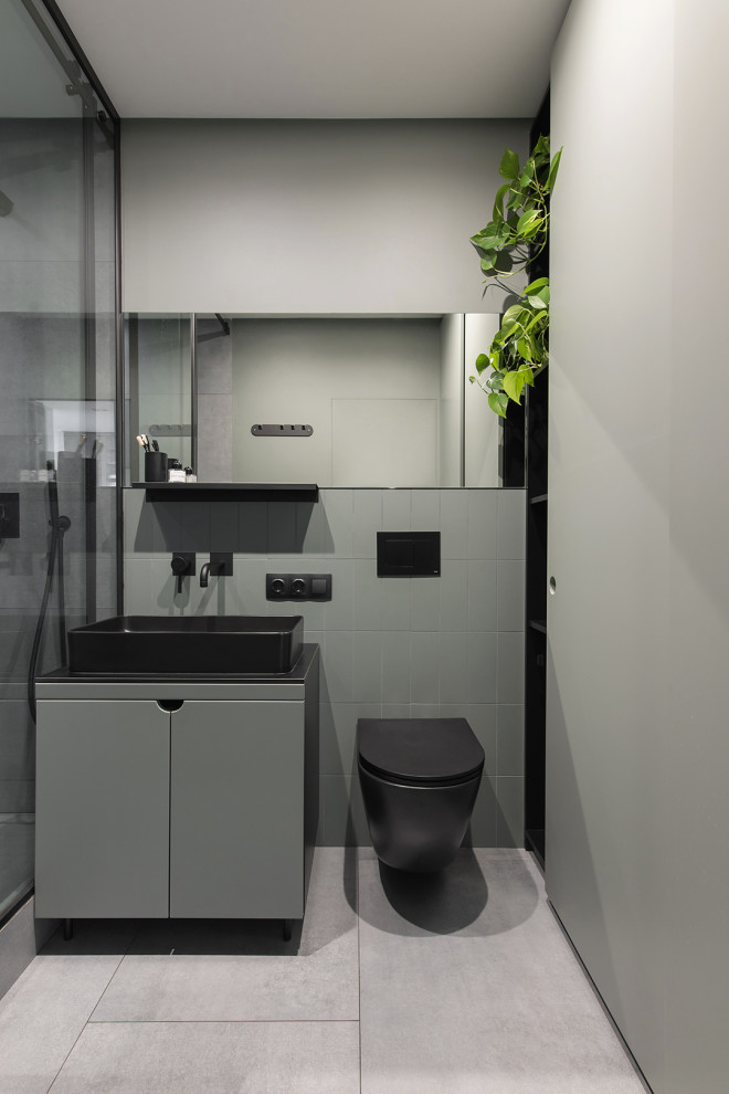 This is an example of a small contemporary cloakroom in Other with green cabinets, green tiles, green walls, grey floors, black worktops and a freestanding vanity unit.