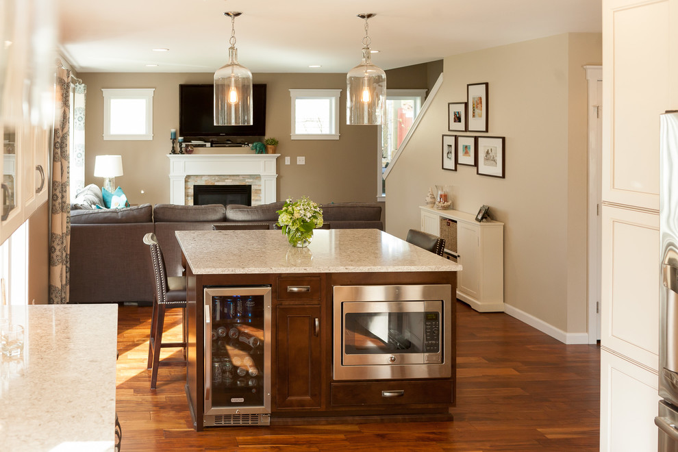 Open concept kitchen - large transitional u-shaped medium tone wood floor open concept kitchen idea with a double-bowl sink, shaker cabinets, white cabinets, quartzite countertops, white backsplash, ceramic backsplash, stainless steel appliances and an island