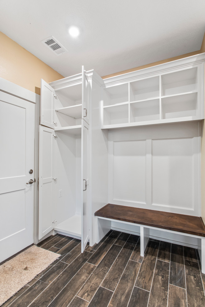 Design ideas for a mid-sized arts and crafts single-wall dedicated laundry room in Other with shaker cabinets, white cabinets, wood benchtops, beige walls and ceramic floors.