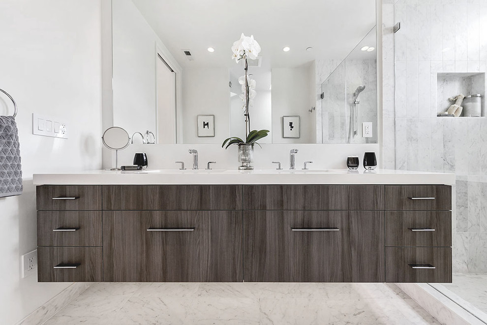 This is an example of a mid-sized contemporary master bathroom in San Francisco with a drop-in sink, flat-panel cabinets, dark wood cabinets, engineered quartz benchtops, an alcove shower, white tile, stone tile, white walls and marble floors.