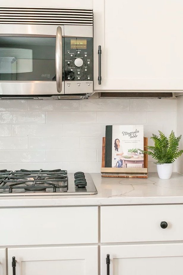 Inspiration for a large transitional u-shaped medium tone wood floor and brown floor eat-in kitchen remodel in Minneapolis with a single-bowl sink, shaker cabinets, white cabinets, quartz countertops, white backsplash, porcelain backsplash, stainless steel appliances, an island and white countertops