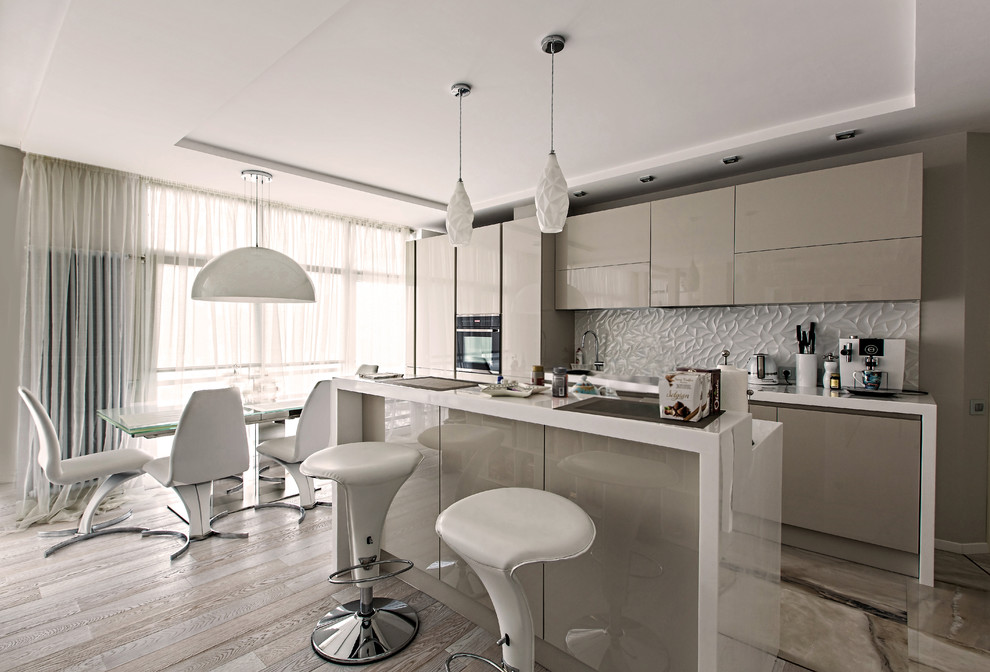 Mid-sized contemporary single-wall open plan kitchen in Moscow with flat-panel cabinets, grey cabinets, white splashback, black appliances, with island, beige floor and white benchtop.