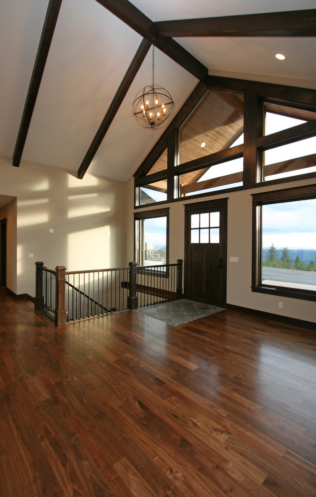 Inspiration for a large rustic medium tone wood floor home design remodel in Seattle with beige walls and a dark wood front door