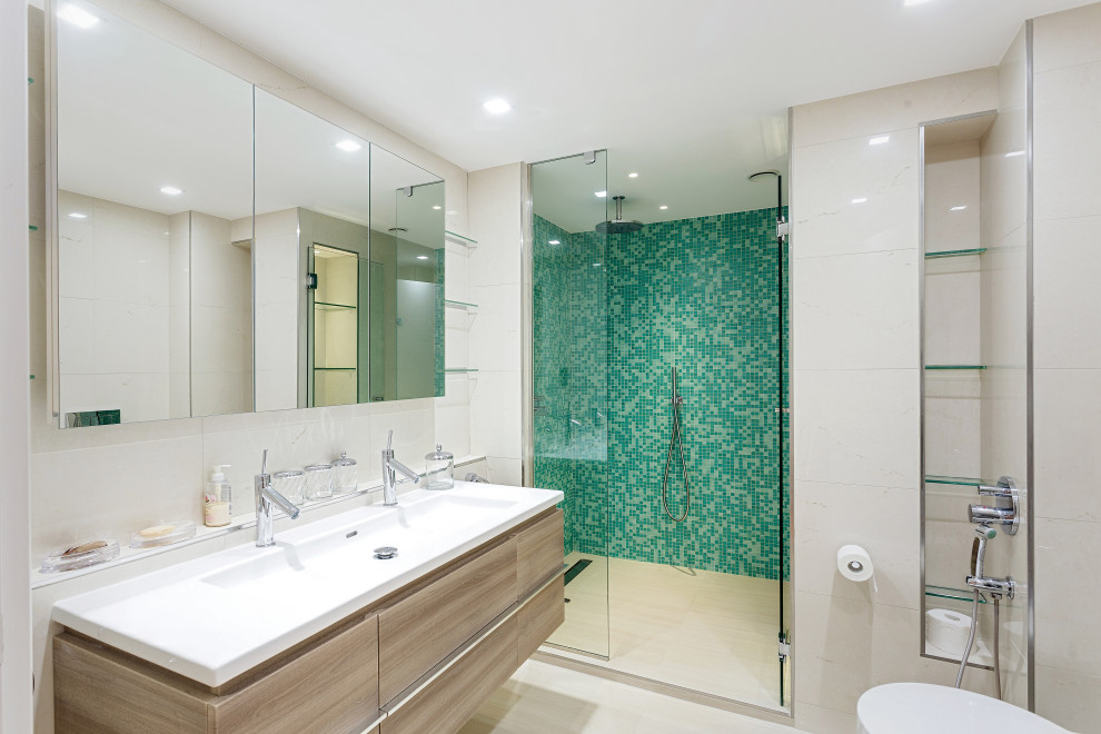 Inspiration for a large contemporary 3/4 bathroom in Nice with flat-panel cabinets, beige cabinets, an alcove shower, a wall-mount toilet, green tile, beige walls, porcelain floors, an integrated sink, beige floor, a hinged shower door and white benchtops.