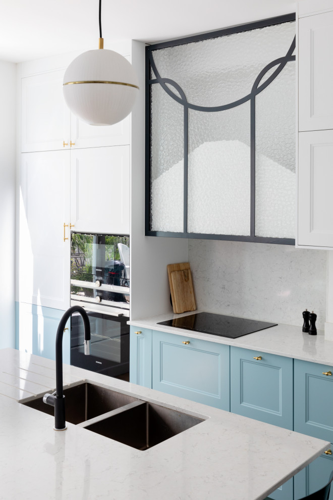 Design ideas for a large traditional l-shaped open plan kitchen in Paris with an undermount sink, recessed-panel cabinets, blue cabinets, quartzite benchtops, white splashback, stone slab splashback, panelled appliances, ceramic floors, with island, black floor and white benchtop.