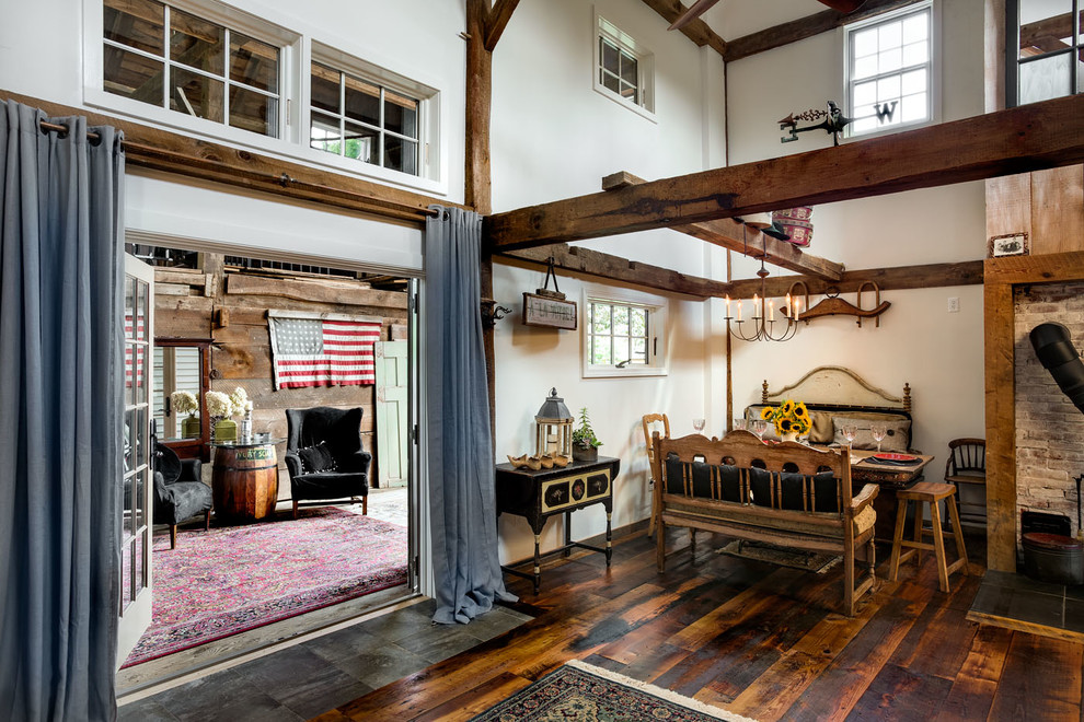 Inspiration for a country dining room in Boston with white walls and dark hardwood floors.