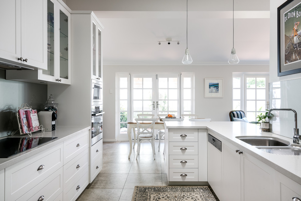 Design ideas for a transitional u-shaped eat-in kitchen in Perth with a double-bowl sink, shaker cabinets, white cabinets, grey splashback, panelled appliances, beige floor and white benchtop.