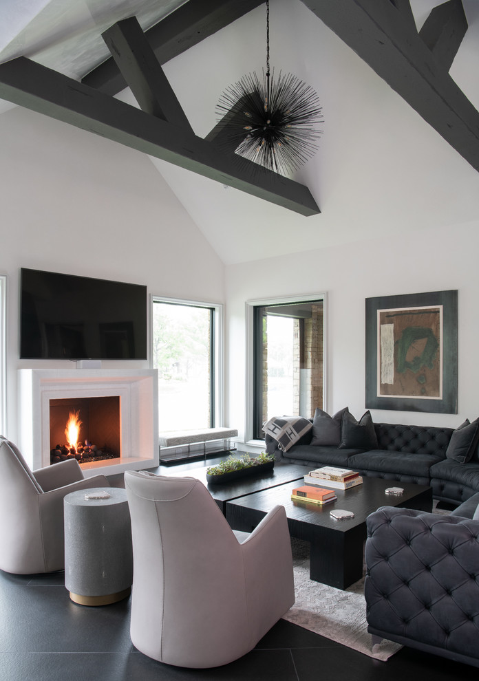 Inspiration for an expansive modern open concept living room in Oklahoma City with white walls, ceramic floors, a standard fireplace, a plaster fireplace surround, a wall-mounted tv and grey floor.