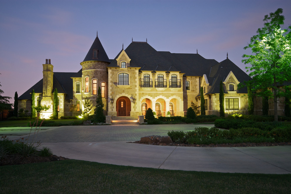 Design ideas for a large mediterranean two-storey beige exterior in Dallas with a hip roof and stone veneer.