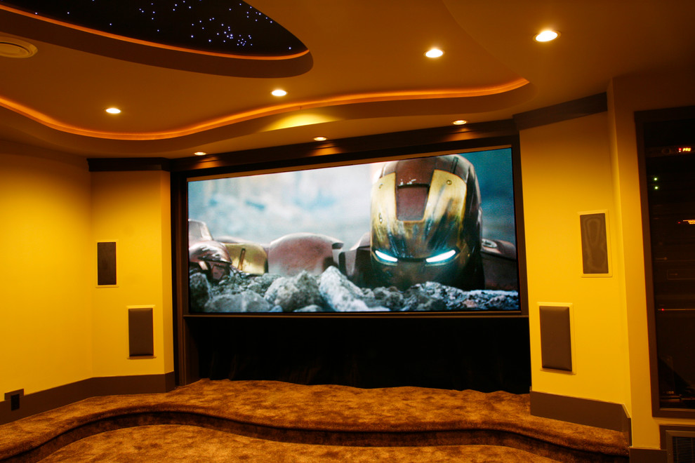 Design ideas for a large contemporary enclosed home theatre in Vancouver with multi-coloured walls, carpet, a projector screen and brown floor.