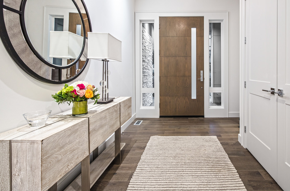This is an example of a mid-sized transitional foyer in Seattle with white walls, medium hardwood floors, a single front door, a medium wood front door and brown floor.