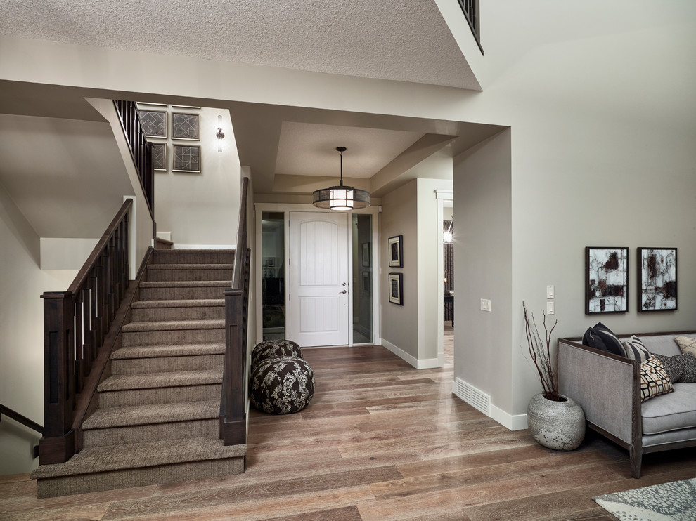 Inspiration for a mid-sized transitional medium tone wood floor foyer remodel in Calgary with white walls and a white front door