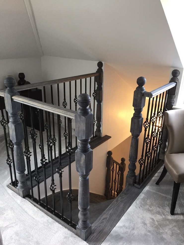 This is an example of a small eclectic wood l-shaped staircase in London with carpet risers.