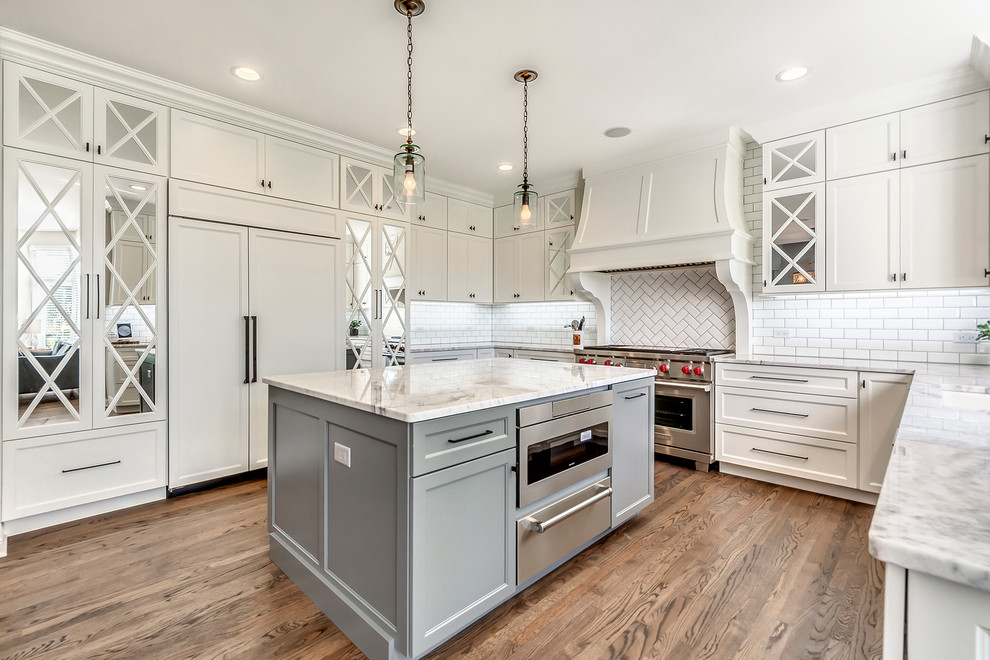 Transitional open concept kitchen photo in Chicago with white backsplash, subway tile backsplash and two islands