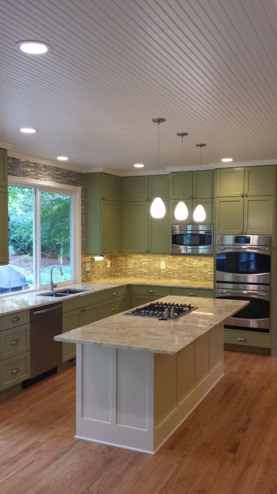 Inspiration for a large transitional u-shaped medium tone wood floor kitchen remodel in Seattle with a double-bowl sink, recessed-panel cabinets, white cabinets, granite countertops, multicolored backsplash, mosaic tile backsplash, stainless steel appliances and an island