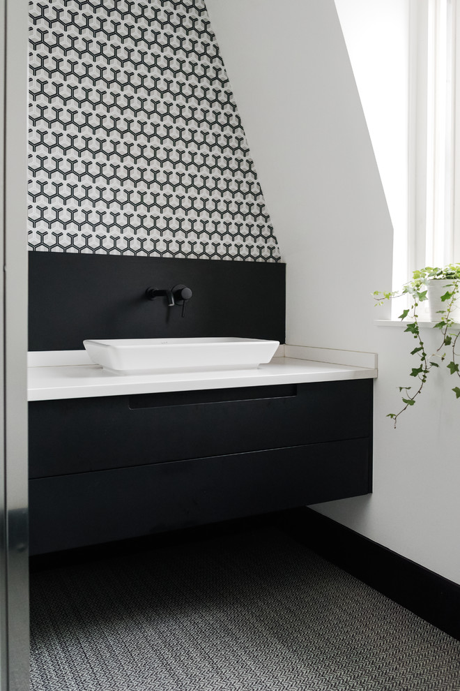 Small contemporary master bathroom in Surrey with flat-panel cabinets, black cabinets, black and white tile, white walls, vinyl floors and an undermount sink.