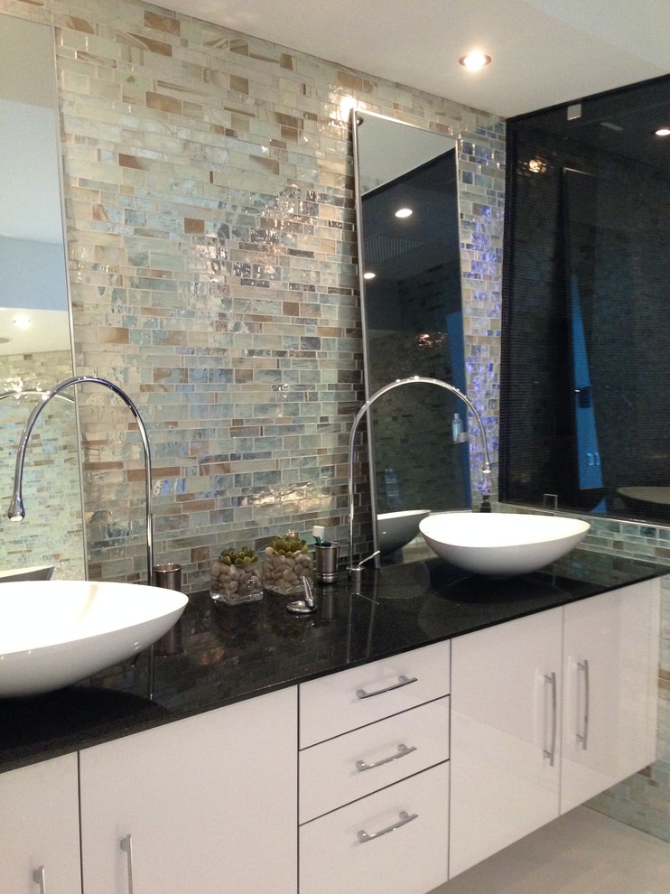 Large modern master bathroom in Miami with a vessel sink, flat-panel cabinets, white cabinets, an alcove tub, an alcove shower, a one-piece toilet, multi-coloured tile, glass tile and multi-coloured walls.