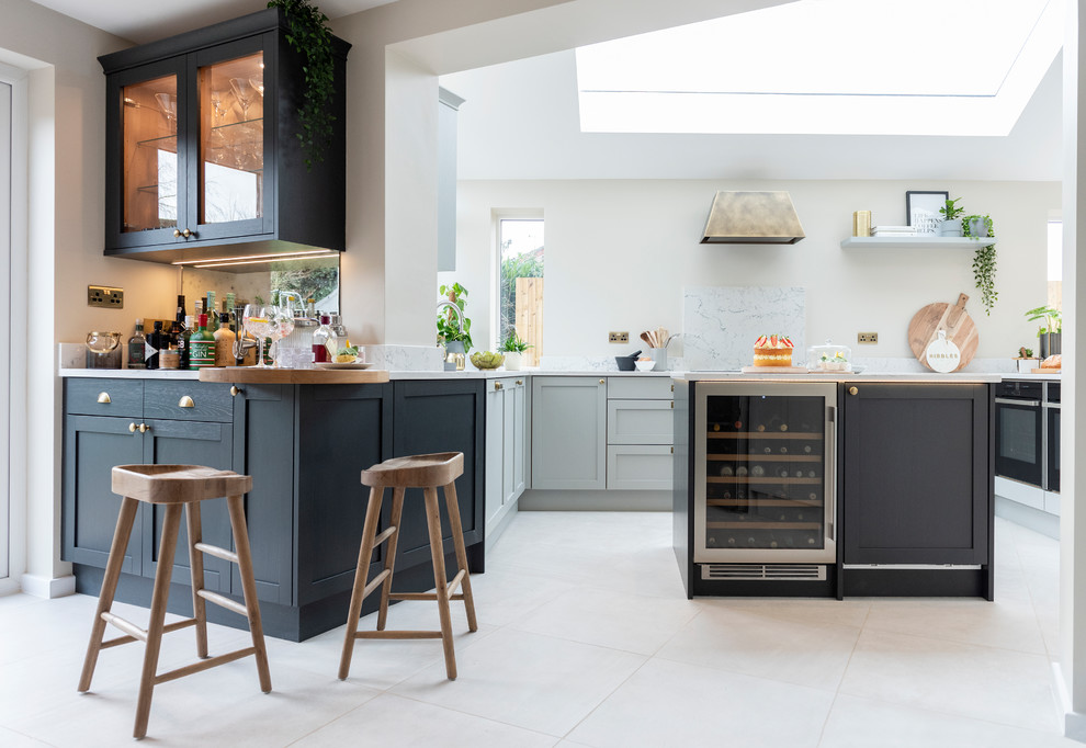 Design ideas for a large scandinavian galley eat-in kitchen in West Midlands with a drop-in sink, shaker cabinets, grey cabinets, marble benchtops, black appliances, ceramic floors, with island, white floor and white benchtop.