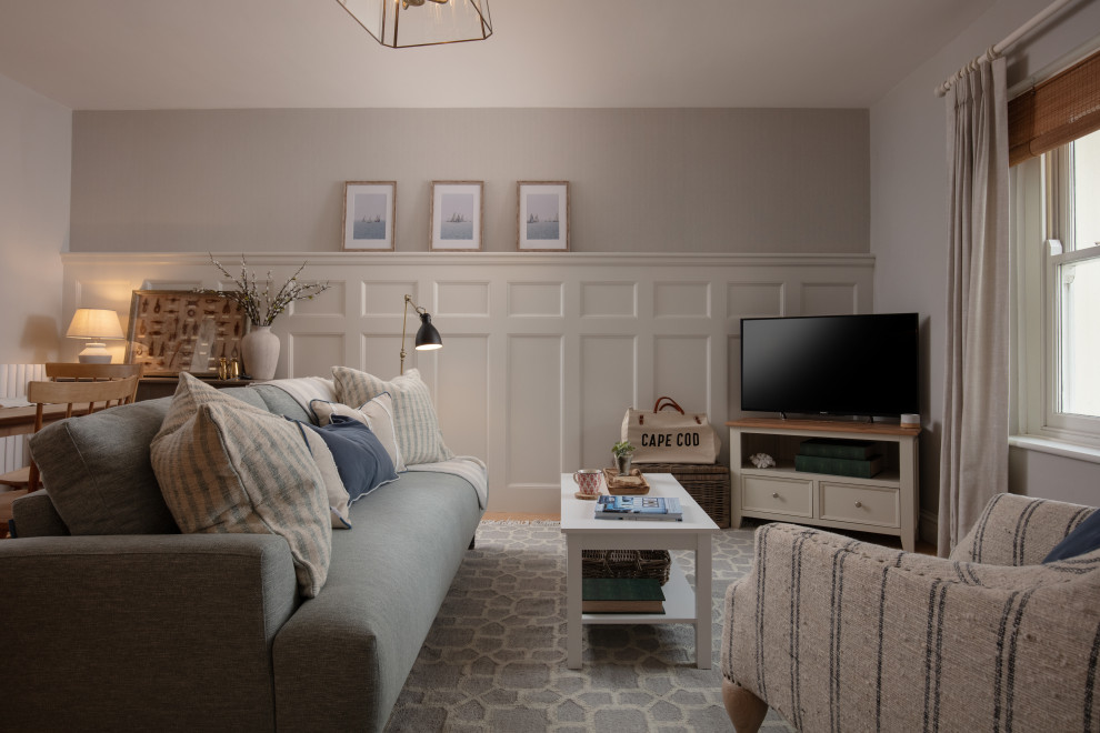 Kleines, Repräsentatives, Offenes Maritimes Wohnzimmer ohne Kamin mit grauer Wandfarbe, braunem Holzboden, Eck-TV, braunem Boden und Wandpaneelen in Cornwall