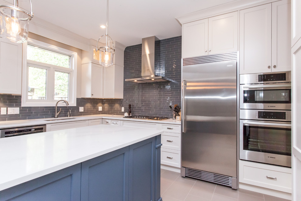 Large transitional u-shaped porcelain tile and gray floor eat-in kitchen photo in Toronto with an undermount sink, recessed-panel cabinets, white cabinets, quartz countertops, gray backsplash, subway tile backsplash, stainless steel appliances, an island and white countertops
