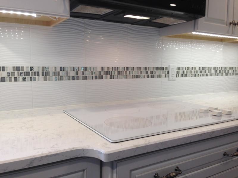 Transitional kitchen photo in Chicago with a double-bowl sink, raised-panel cabinets, white cabinets, quartzite countertops, white backsplash and porcelain backsplash