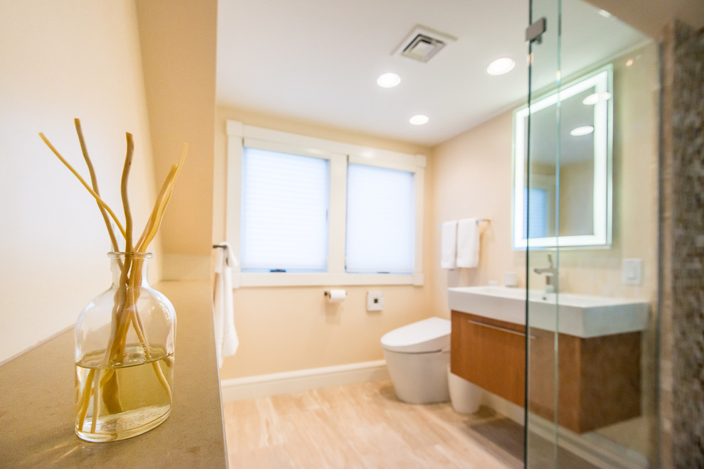 Mid-sized contemporary 3/4 bathroom in Boston with a console sink, flat-panel cabinets, medium wood cabinets, engineered quartz benchtops, a curbless shower, a one-piece toilet, multi-coloured tile, glass tile, beige walls and limestone floors.