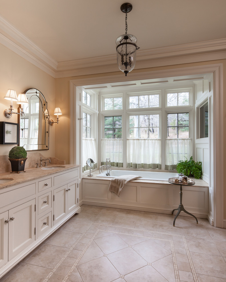 Inspiration for a large country master bathroom in New York with shaker cabinets, white cabinets, an alcove tub, beige walls, limestone floors, an undermount sink and limestone benchtops.