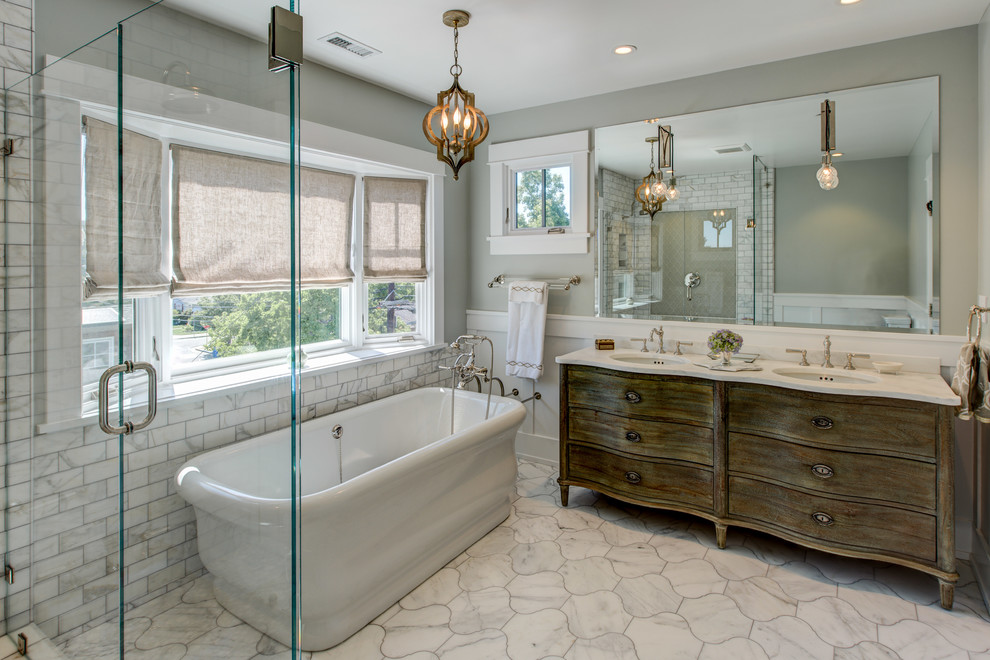 Mid-sized arts and crafts master bathroom in San Francisco with distressed cabinets, a freestanding tub, a corner shower, a two-piece toilet, white tile, subway tile, grey walls, marble floors, an undermount sink and marble benchtops.