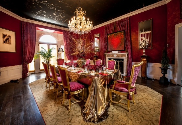 Inspiration for a large traditional dining room in New York with red walls, medium hardwood floors, a two-sided fireplace and a stone fireplace surround.