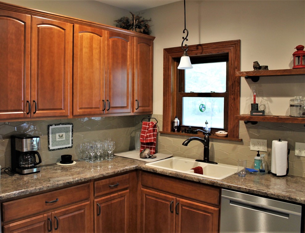 Example of a mid-sized mountain style l-shaped vinyl floor and beige floor eat-in kitchen design with a farmhouse sink, raised-panel cabinets, medium tone wood cabinets, laminate countertops, beige backsplash, cement tile backsplash, stainless steel appliances, a peninsula and beige countertops