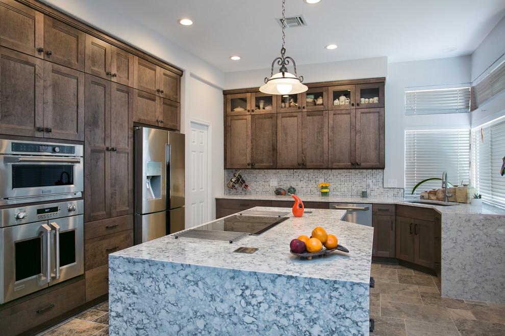 Example of a porcelain tile kitchen design in Phoenix with an undermount sink, shaker cabinets, gray cabinets, quartz countertops, white backsplash, ceramic backsplash, stainless steel appliances and an island