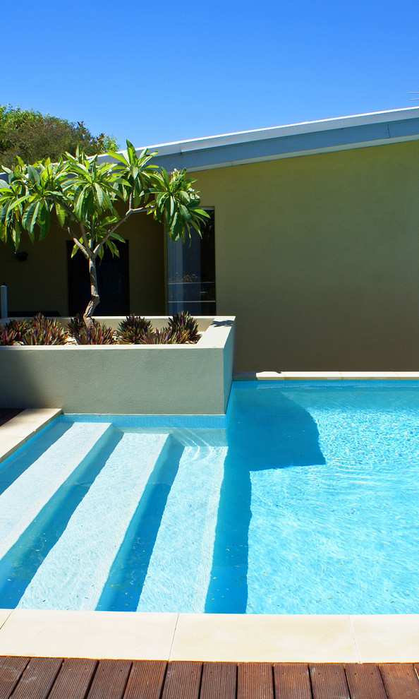 Photo of a mid-sized modern backyard rectangular aboveground pool in Perth with decking.