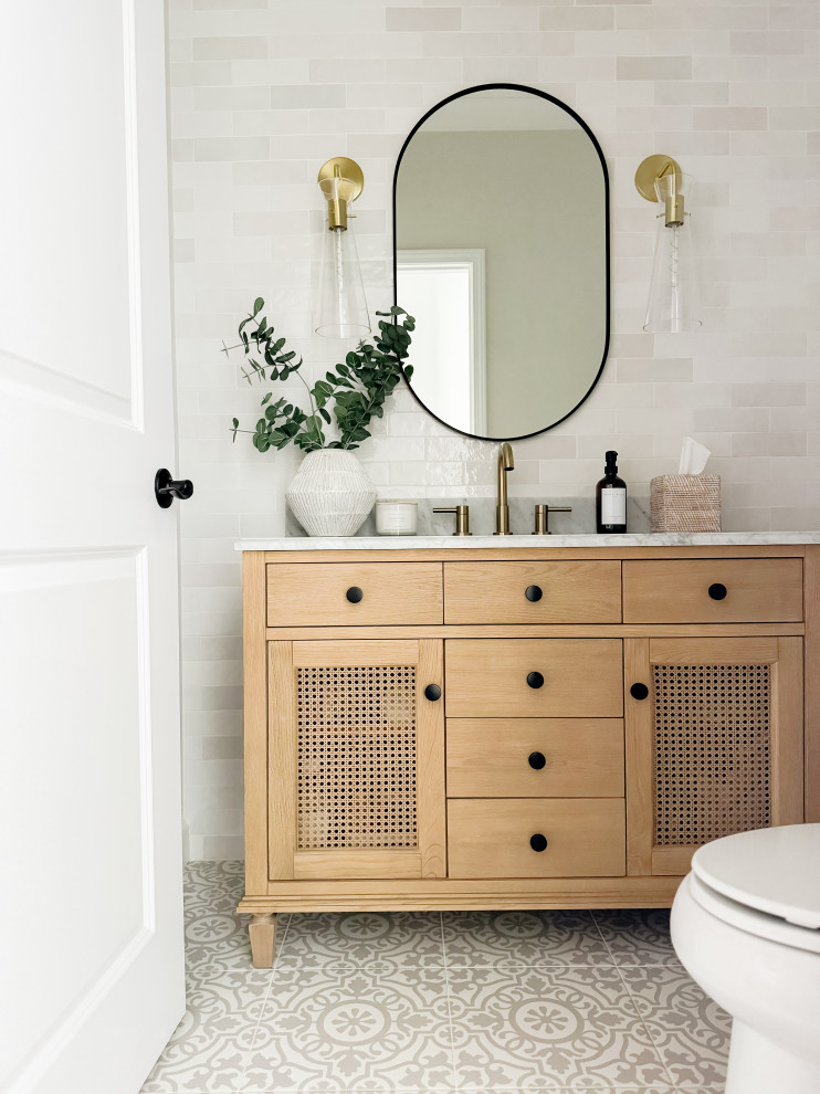 Small contemporary powder room in Detroit with furniture-like cabinets, light wood cabinets, a two-piece toilet, white tile, ceramic tile, grey walls, porcelain floors, an undermount sink, marble benchtops, grey floor, grey benchtops and a freestanding vanity.