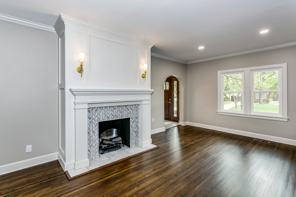 This is an example of a mid-sized traditional living room in Wichita with grey walls, dark hardwood floors, a standard fireplace, a tile fireplace surround and brown floor.