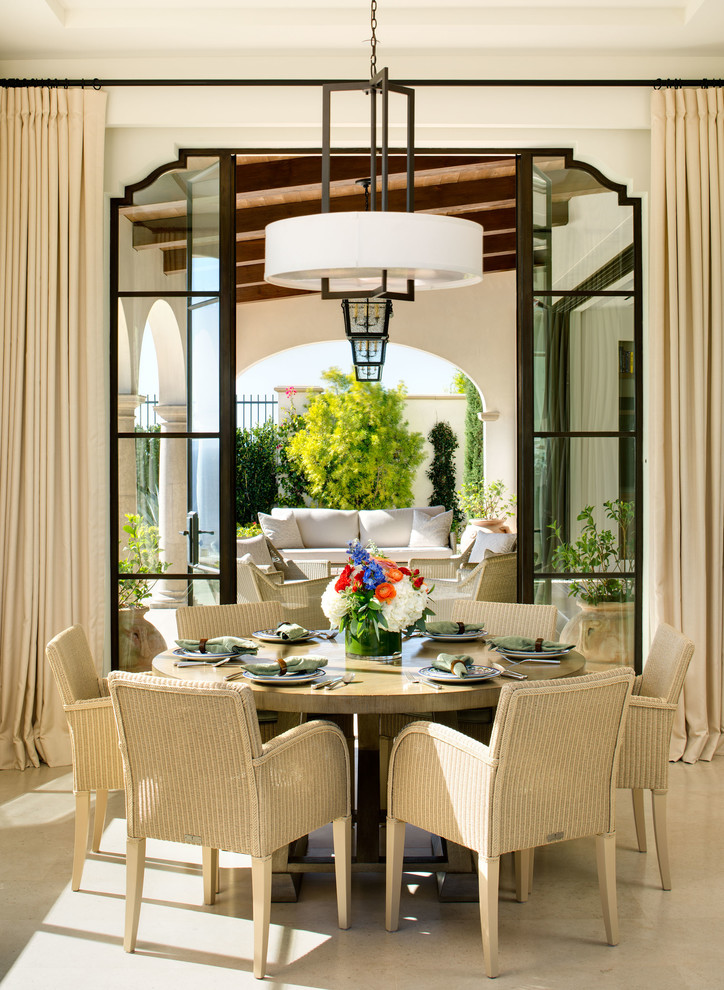 Inspiration for a mediterranean dining room in Orange County with white walls and beige floor.