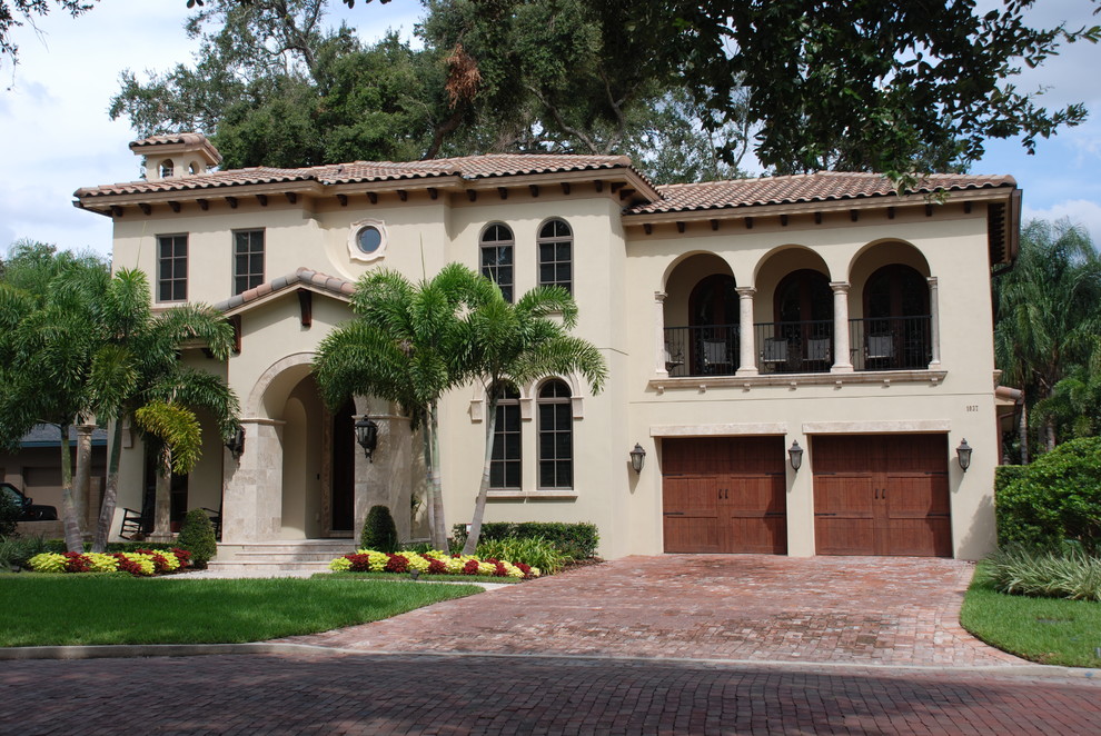 Design ideas for a mid-sized mediterranean one-storey stucco beige exterior in Orlando with a gable roof.