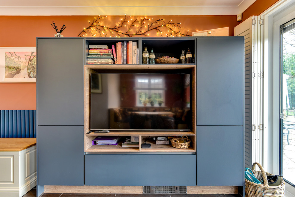 Large modern grey and teal u-shaped kitchen/diner in Sussex with a built-in sink, flat-panel cabinets, blue cabinets, composite countertops, blue splashback, glass sheet splashback, integrated appliances, vinyl flooring, no island, brown floors, white worktops and feature lighting.