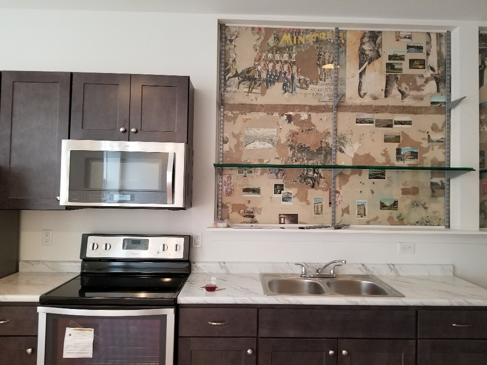 Example of a small transitional single-wall kitchen design with a double-bowl sink, recessed-panel cabinets, dark wood cabinets, white backsplash, stainless steel appliances, no island, white countertops and laminate countertops