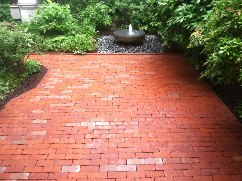 Design ideas for a traditional courtyard patio in Boston with a water feature, brick pavers and no cover.