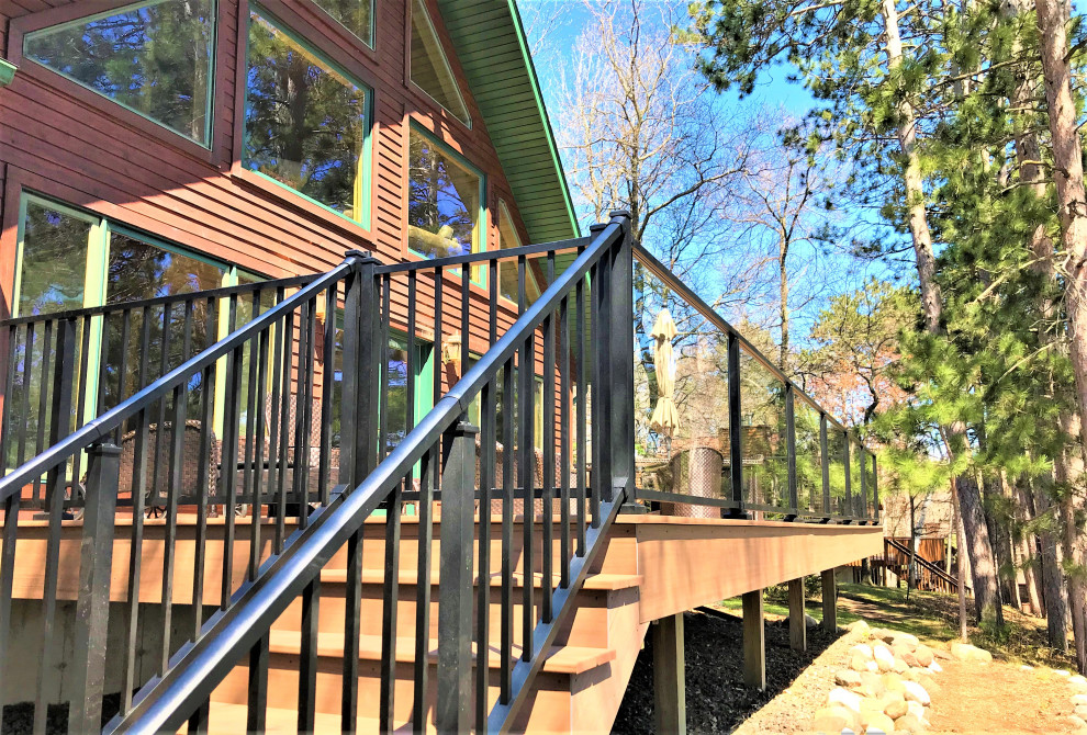 Large country backyard and ground level deck in Minneapolis with no cover and mixed railing.