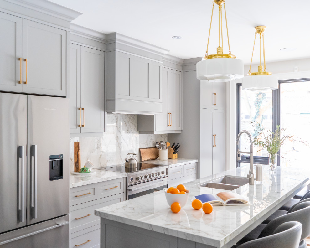 Transitional galley kitchen in Toronto with a double-bowl sink, shaker cabinets, grey cabinets, marble benchtops, multi-coloured splashback, marble splashback, stainless steel appliances, medium hardwood floors, with island, brown floor and multi-coloured benchtop.